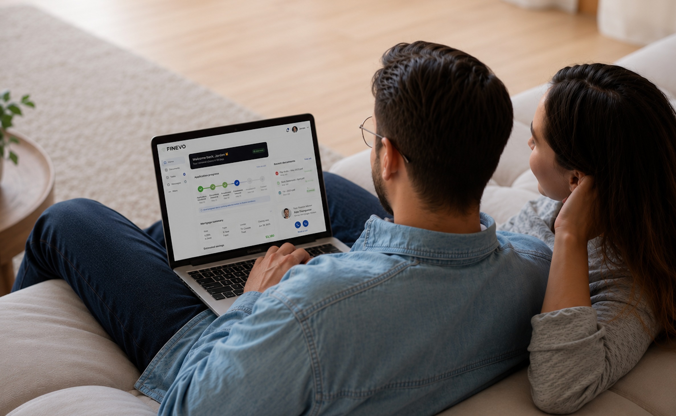 A couple smiling as they review their Finevo mortgage dashboard together on a laptop at home