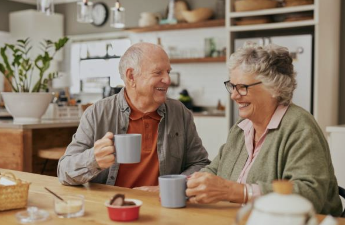 An active Canadian couple in their 60s relaxing happily in the living room of their own home